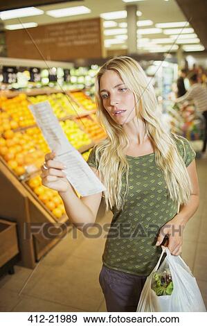 Frustrated woman reading receipt in grocery store View Large Photo Image Stock Photo - Frustrated woman reading receipt in grocery store. Fotosearch