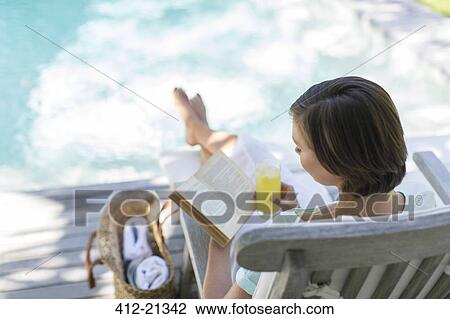 High angle view of woman reading and drinking juice by swimming pool View Large Photo Image Stock Image - High angle view of woman reading and drinking juice by swimming pool. Fotosearch