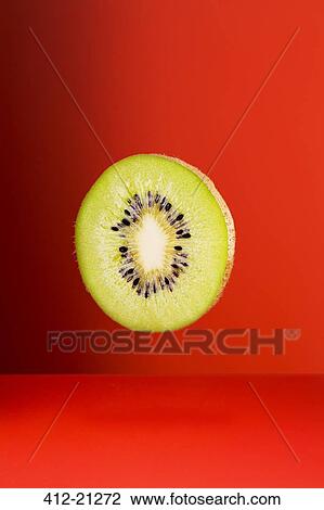 Kiwi slice on red counter View Large Photo Image Stock Image - Kiwi slice on red counter. Fotosearch