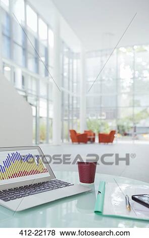 Stock Photo - laptop on work desk in office building. Fotosearch