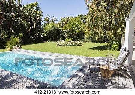 Lawn chairs overlooking backyard and swimming pool View Large Photo Image Stock Photo - Lawn chairs overlooking backyard and swimming pool. Fotosearch