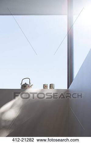 Low angle view of teapot and cups on windowsill View Large Photo Image Stock Image - Low angle view of teapot and cups on windowsill. Fotosearch