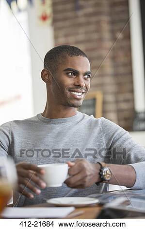 Picture - Man having coffee in cafe. Fotosearch