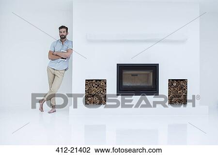Man leaning on modern fireplace View Large Photo Image Stock Image - Man leaning on modern fireplace. Fotosearch