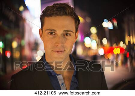 Man smiling on city street at night View Large Photo Image Stock Photograph - Man smiling on city street at night. Fotosearch