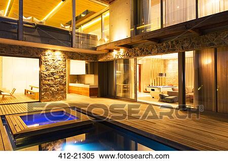 Modern house overlooking illuminated swimming pool at night View Large Photo Image Stock Photography - Modern house overlooking illuminated swimming pool at night. Fotosearch