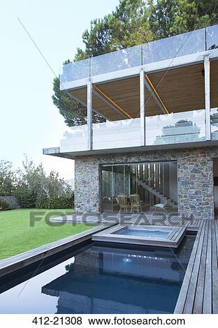 Modern house overlooking swimming pool and wooden deck View Large Photo Image Stock Photo - Modern house overlooking swimming pool and wooden deck. Fotosearch
