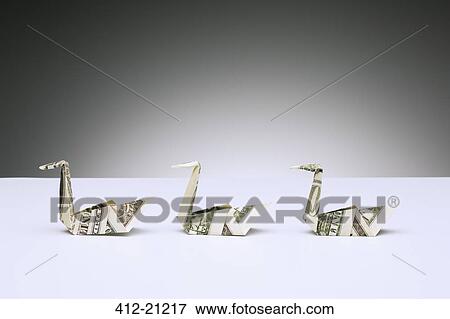 Origami swans made of dollar bills on counter View Large Photo Image Stock Photo - Origami swans made of dollar bills on counter. Fotosearch