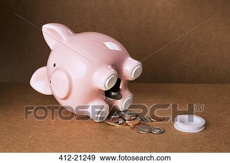Piggy bank spilling out change onto counter View Large Photo Image Stock Photo - Piggy bank spilling out change onto counter. Fotosearch