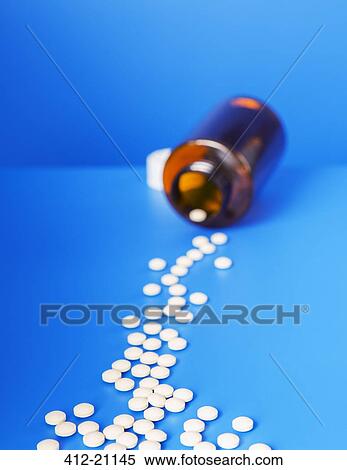 Prescription pills spilling from bottle onto blue counter View Large Photo Image Stock Photography - Prescription pills spilling from bottle onto blue counter. Fotosearch