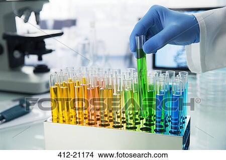 Scientist picking test tube out of rack on counter in lab View Large Photo Image Picture - Scientist picking test tube out of rack on counter in lab. Fotosearch
