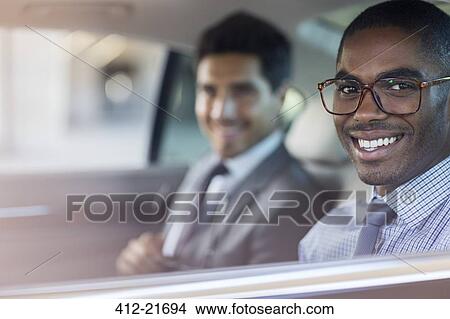 Smiling businessmen sitting in car View Large Photo Image Picture - Smiling businessmen sitting in car . Fotosearch