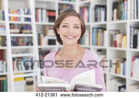 Smiling woman reading in living room View Large Photo Image Stock Image - Smiling woman reading in living room. Fotosearch