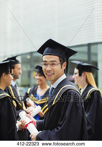 Student in cap and gown standing with friends View Large Photo Image Stock Image - Student in cap and gown standing with friends. Fotosearch
