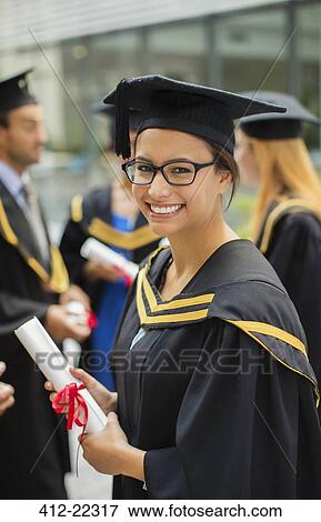 Student in cap and gown standing with friends View Large Photo Image Stock Photo - Student in cap and gown standing with friends. Fotosearch