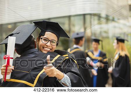 Stock Photograph - Students in cap and gown hugging. Fotosearch