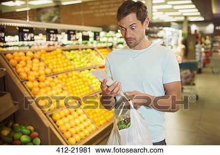 Surprised man reading receipt in grocery store View Large Photo Image Stock Image - Surprised man reading receipt in grocery store. Fotosearch
