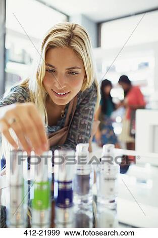 Woman examining skincare products in drugstore View Large Photo Image Stock Photo - Woman examining skincare products in drugstore. Fotosearch