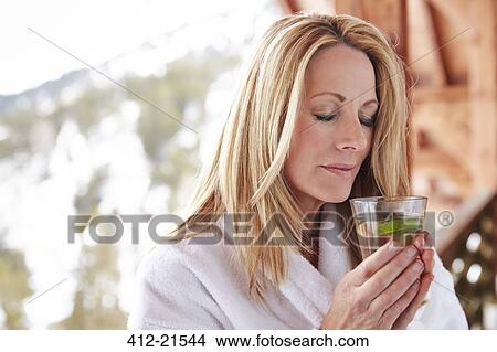 Woman holding drink on cabin balcony View Large Photo Image Picture - Woman holding drink on cabin balcony . Fotosearch