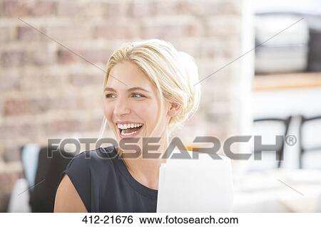 Woman laughing in office View Large Photo Image Stock Photograph - Woman laughing in office . Fotosearch