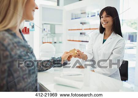 Woman paying with credit card in drugstore View Large Photo Image Stock Photo - Woman paying with credit card in drugstore. Fotosearch