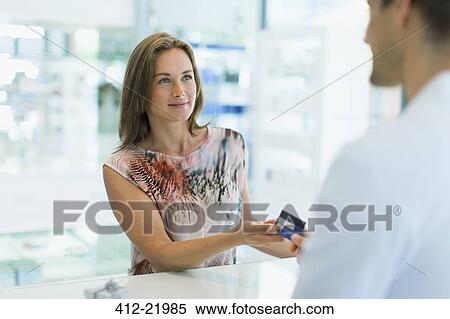 Woman paying with credit card in drugstore View Large Photo Image Stock Photography - Woman paying with credit card in drugstore. Fotosearch