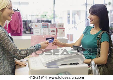 Woman paying with credit card in store View Large Photo Image Picture - Woman paying with credit card in store. Fotosearch