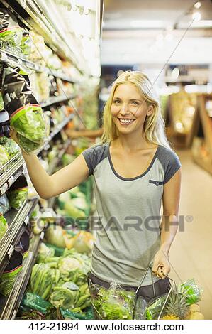 Woman shopping in grocery store View Large Photo Image Picture - Woman shopping in grocery store. Fotosearch