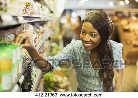 Stock Image - Woman shopping in grocery store. Fotosearch