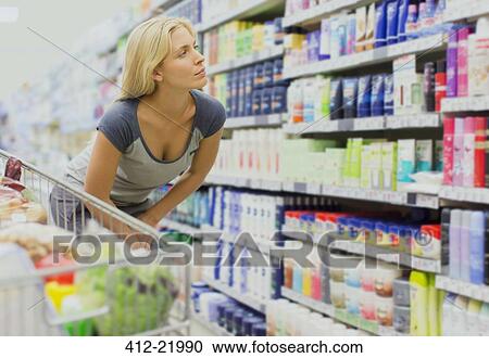 Stock Image - Woman shopping in grocery store. Fotosearch