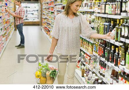 Woman shopping in grocery store View Large Photo Image Stock Image - Woman shopping in grocery store. Fotosearch