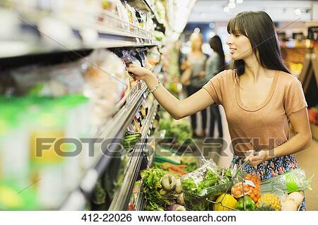 Stock Photograph - Woman shopping in grocery store. Fotosearch