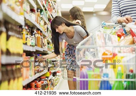 Stock Photography - Woman shopping in grocery store. Fotosearch