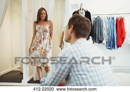 Woman trying on clothes for boyfriend in clothing store View Large Photo Image Stock Image - Woman trying on clothes for boyfriend in clothing store. Fotosearch