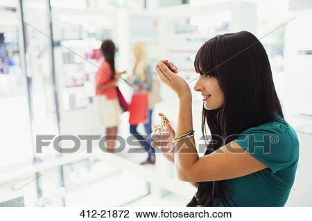 Woman trying out perfume in drugstore View Large Photo Image Stock Image - Woman trying out perfume in drugstore. Fotosearch