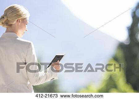 Woman using digital tablet outdoors View Large Photo Image Stock Image - Woman using digital tablet outdoors. Fotosearch
