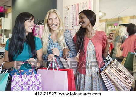 Women carrying shopping bags in store View Large Photo Image Stock Photo - Women carrying shopping bags in store. Fotosearch