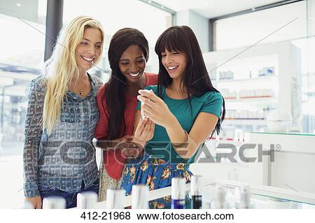 Women examining skincare products in drugstore View Large Photo Image Stock Photo - Women examining skincare products in drugstore. Fotosearch