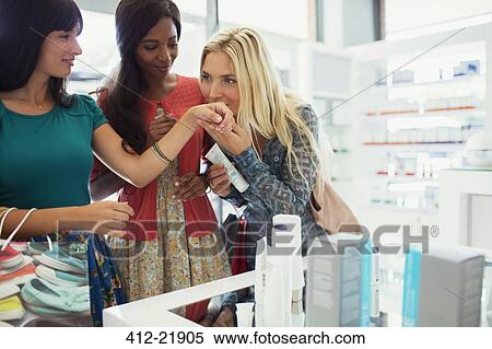 Women smelling perfume in drugstore View Large Photo Image Stock Photography - Women smelling perfume in drugstore. Fotosearch