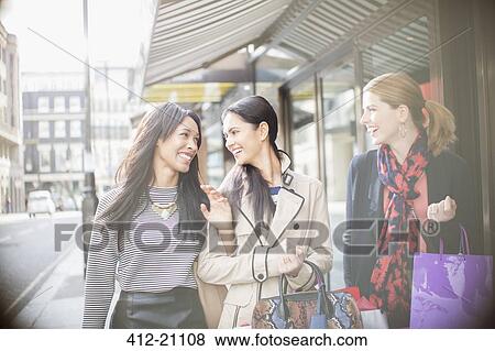 Stock Photo - Women walking down city street together. Fotosearch