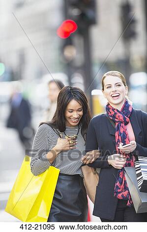 Stock Photography - Women walking together on city street . Fotosearch