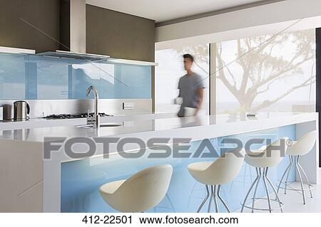 Blurred motion man walking through white and blue modern kitchen View Large Photo Image Stock Image - Blurred motion man walking through white and blue modern kitchen. Fotosearch