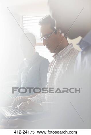 Business people working in office, using laptop View Large Photo Image Stock Photography - Business people working in office, using laptop. Fotosearch