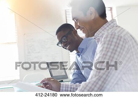 Stock Image - Businessmen working in office. Fotosearch