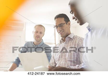 Stock Photo - Businessmen working with laptop in office. Fotosearch