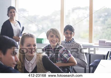 Cheerful high school students with their teacher in classroom View Large Photo Image Stock Photo - Cheerful high school students with their teacher in classroom. Fotosearch