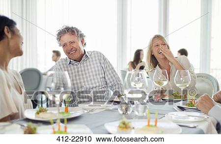 Cheerful people laughing at restaurant table View Large Photo Image Stock Image - Cheerful people laughing at restaurant table. Fotosearch