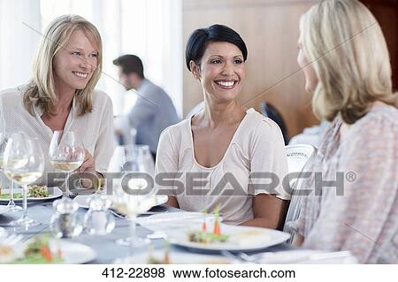 Cheerful women in restaurant, man in background View Large Photo Image Stock Photo - Cheerful women in restaurant, man in background. Fotosearch