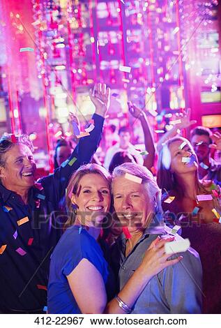 Confetti falling on smiling mature people dancing in nightclub View Large Photo Image Stock Photo - Confetti falling on smiling mature people dancing in nightclub. Fotosearch