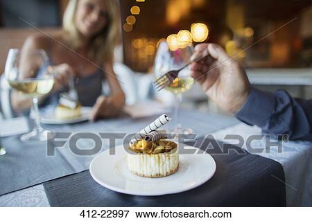 Couple eating dessert in fancy restaurant View Large Photo Image Stock Photo - Couple eating dessert in fancy restaurant. Fotosearch